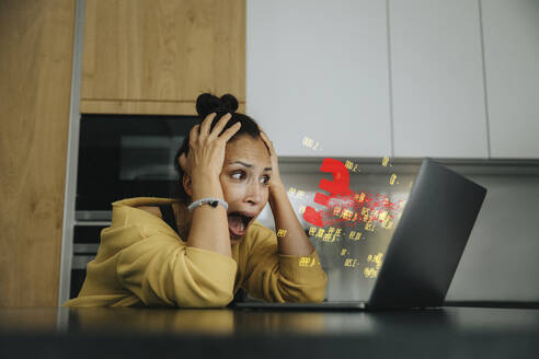 Woman with head in hands screaming while looking at laptop - LIFIF00049