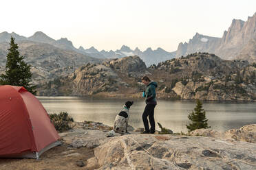 Seitenansicht einer Frau beim Camping mit Hund im Urlaub - CAVF94224