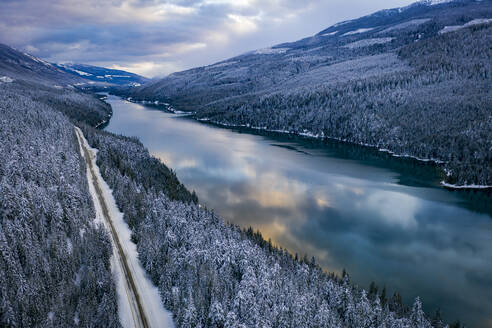 Idyllic shot of river amidst mountains in winter at sunset - CAVF94266