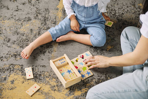 Mutter und Tochter spielen mit Spielzeug auf dem Boden des Wohnzimmers zu Hause - AODF00535