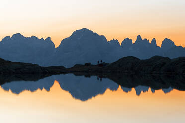 Die Berge der Brenta-Dolomiten spiegeln sich im kristallklaren Wasser des Lago Nero di Cornisello bei Sonnenaufgang, Trentino-Südtirol, Italien, Europa - RHPLF19802