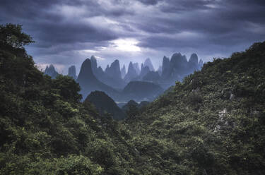 Yangshuo Berge mit dunklen Wolken umrahmt von Hügeln, Yangshuo, Guangxi, China, Asien - RHPLF19870