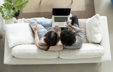 From above couple browsing laptop on couch in house room - ADSF25208