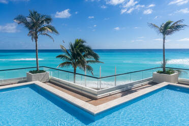 Swimmingpool mit Blick auf das türkisfarbene Wasser von Cancun, Quintana Roo, Mexiko, Nordamerika - RHPLF19900