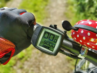 Hand by speedometer on bicycle handlebar - LAF02717