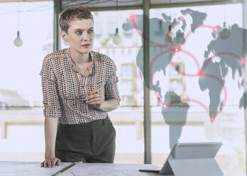 Businesswoman leaning at desk while looking at networking data - UUF23637