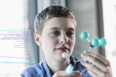 Businesswoman looking at molecular structure at office - UUF23647