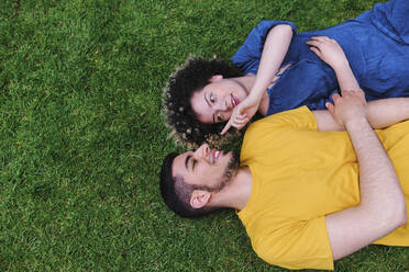 Junge Frau mit Freund im Gras liegend im Park - ASGF00664