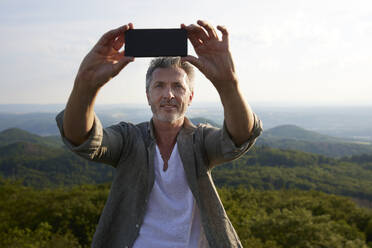 Mann nimmt Selfie durch Smartphone - FMKF07232
