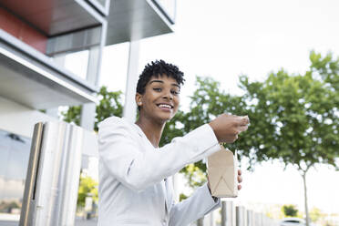 Businesswoman eating take out food - JCCMF02926