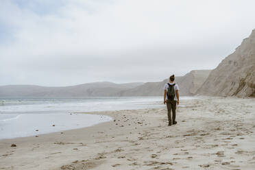 Junger Mann, der am Strand von Point Reyes, Kalifornien, USA, im Sand spazieren geht - AFVF09024