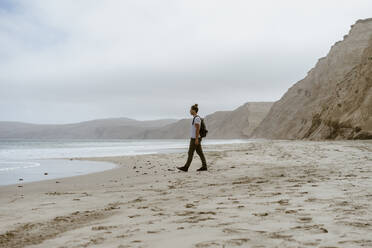 Man walking near sea on beach at Point Reyes in California, USA - AFVF09025