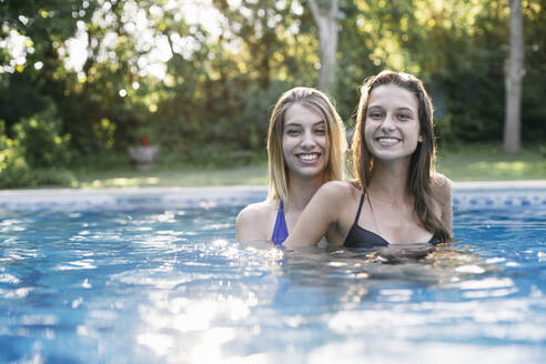 Lächelnde Frau hat Spaß im Schwimmbad im Urlaub - ABZF03593