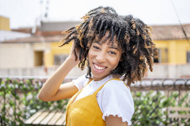 Afro-Frau mit Kopf in den Händen auf dem Balkon - OCMF02173