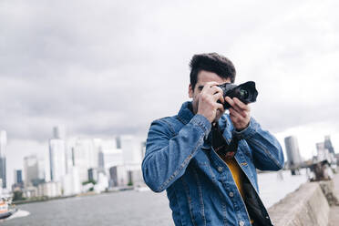 Mann beim Fotografieren mit Kamera an der Promenade - ASGF00686