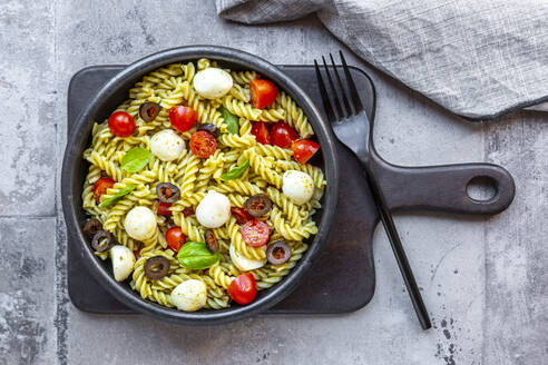 Schüssel mit verzehrfertigem Nudelsalat mit Kirschtomaten, Oliven, Mozzarellakäse und Basilikum - SARF04661