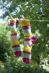 Pair of colorful socks drying on clothesline - GISF00816