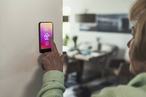 Woman touching wifi icon on home automation device - UUF23651