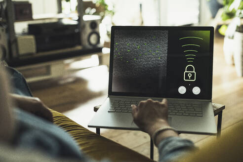 Woman accessing security system on laptop at home - UUF23684