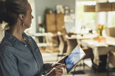 Ältere Frau benutzt digitales Tablet zu Hause - UUF23706