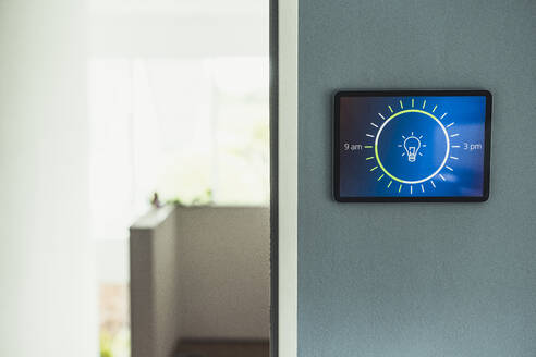 Hausautomatisierung mit Glühbirnensymbol auf einem an der Wand montierten Bildschirm zu Hause - UUF23711