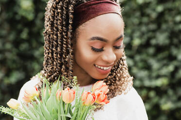 Schöne lächelnde junge Frau mit Blumen - NMSF00433