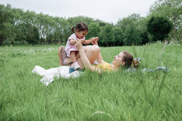 Mother playing with daughter in park - ASGF00721