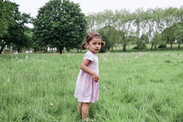 Carefree girl standing on grass in park - ASGF00725