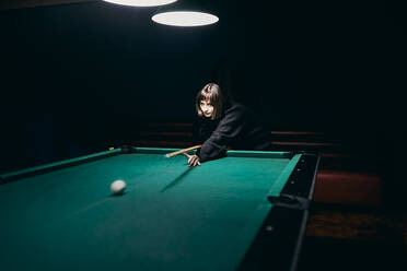 Junges Mädchen spielt Pool in einer Bar - CAVF94310