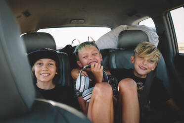 Three Best Friends on a Road Trip Giggle from the Backseat - CAVF94328
