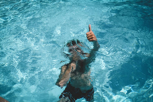 Boy Gives a Thumbs up While Holding Breath Underwater - CAVF94332