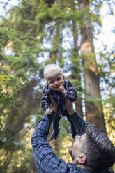 Father lifts his young son into the air - CAVF94352