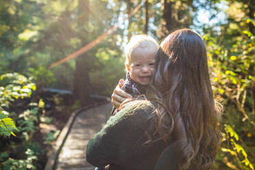 Happy boy looking over mothers shoulder. - CAVF94354