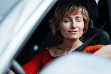 Geschäftsfrau sitzt mit geschlossenen Augen im Auto - JOSEF05022