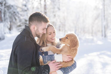 Fröhlicher Mann und Frau mit Hund im Winter - MEF00110