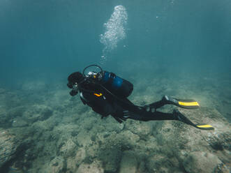 Frau mit Aqualung beim Unterwassertauchen - RSGF00738