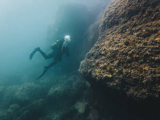 Frau mit Aqualung taucht unter Wasser im Meer - RSGF00740