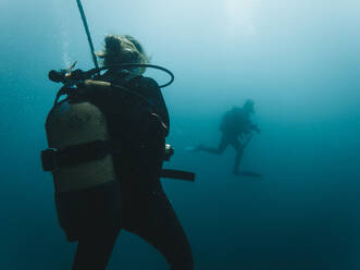 Männliche und weibliche Taucher bei der Erkundung im Meer - RSGF00746