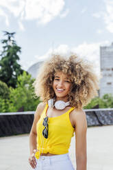 Lächelnde schöne junge Afro-Frau stehend mit Hand auf der Hüfte - PGF00641