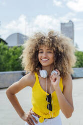 Lächelnde schöne Afro-Frau stehend mit Hand auf der Hüfte - PGF00644