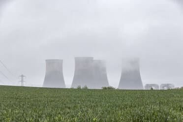 UK, England, Rugeley, Große Kühltürme bei nebligem Wetter mit Feld im Vordergrund - WPEF04929