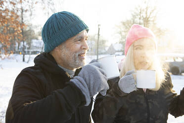 Senior couple having drink together during winter - FVDF00284