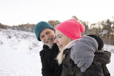 Smiling man with arm around woman during winter - FVDF00297