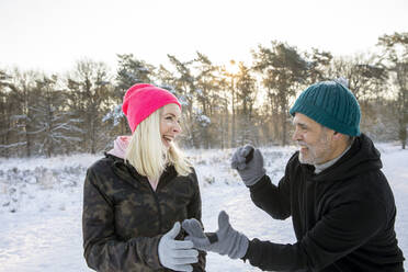 Playful senior man and woman enjoying winter together - FVDF00308