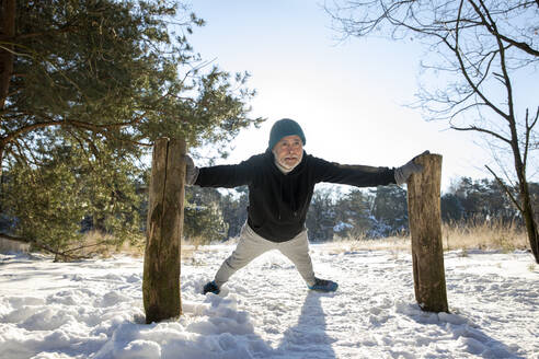 Aktiver älterer Mann beim Training im Schnee - FVDF00324