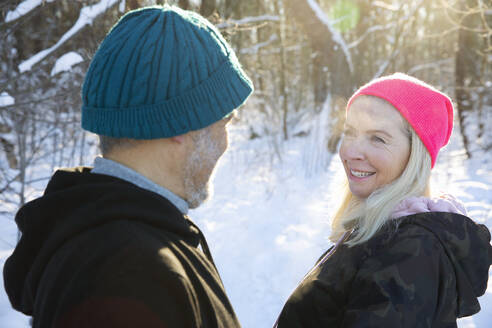 Ältere Frau lächelt und sieht einen Mann im Winter an - FVDF00332