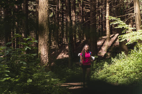 Junge Frau beim Wandern im Wald am Wochenende - FMOF01439