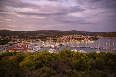 Illuminated harbor by town at dusk, Rogoznica, Dalmatia, Croatia - MAMF01904