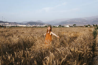 Woman standing in wheat field - TCEF01975
