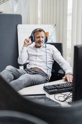 Male professional with headset sitting in office - DIGF16040